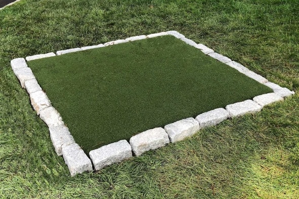 Huntsville Tee box made of synthetic grass surrounded by stone border